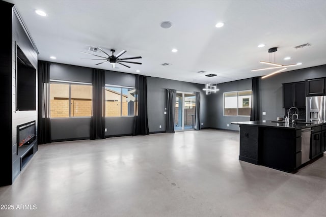 kitchen with pendant lighting, a center island with sink, ceiling fan with notable chandelier, sink, and stainless steel dishwasher