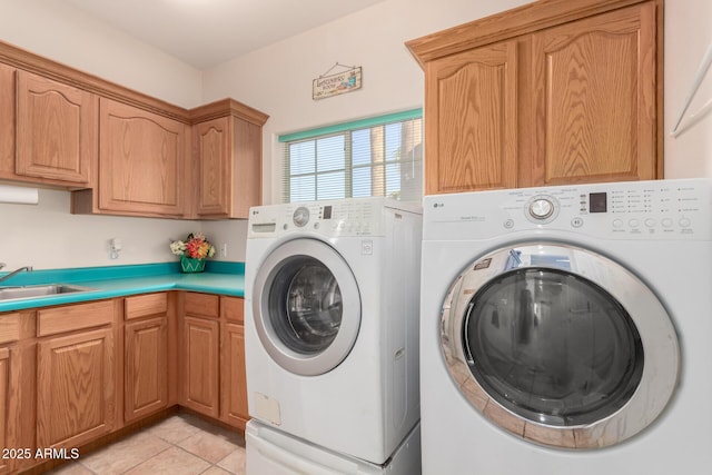 laundry area with cabinets, washing machine and dryer, sink, and light tile patterned floors