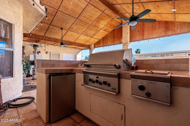 exterior space featuring vaulted ceiling, tile countertops, stainless steel fridge, ceiling fan, and wood ceiling