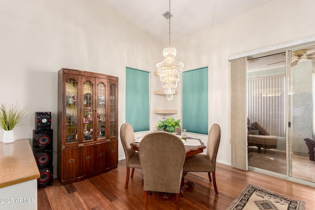 dining room featuring hardwood / wood-style flooring, high vaulted ceiling, and a chandelier