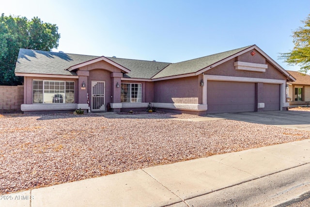 ranch-style home featuring a shingled roof, an attached garage, driveway, and stucco siding