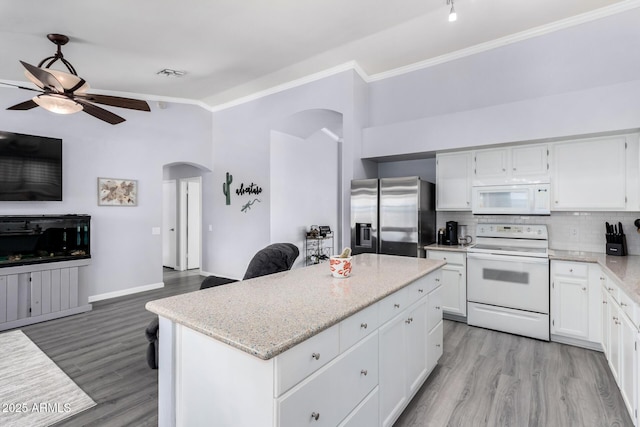 kitchen featuring a ceiling fan, tasteful backsplash, open floor plan, white appliances, and arched walkways