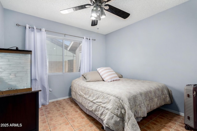 bedroom with light tile patterned floors, baseboards, and a textured ceiling