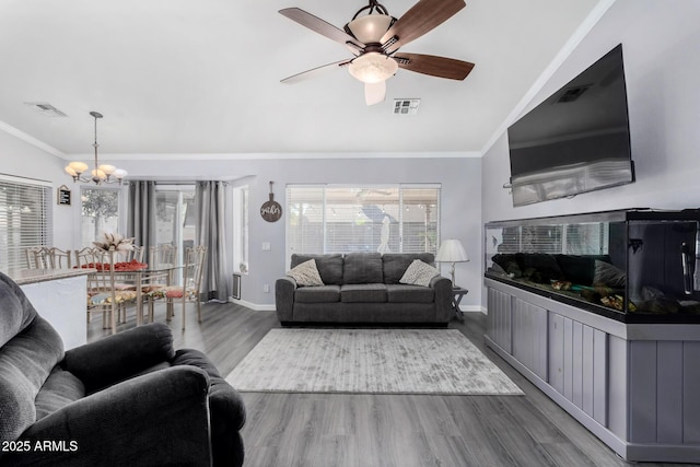 living room featuring visible vents, wood finished floors, crown molding, and ceiling fan with notable chandelier