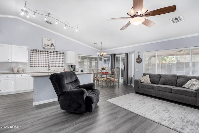 living area with vaulted ceiling, visible vents, and ornamental molding