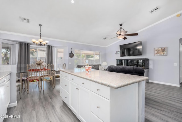 kitchen with visible vents, wood finished floors, crown molding, and ceiling fan with notable chandelier