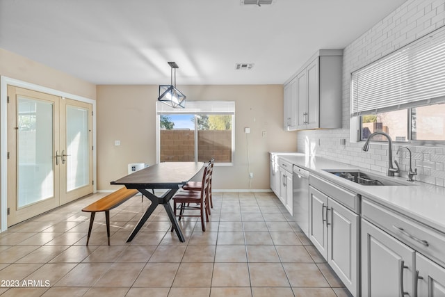 kitchen featuring dishwasher, hanging light fixtures, french doors, light tile patterned flooring, and sink