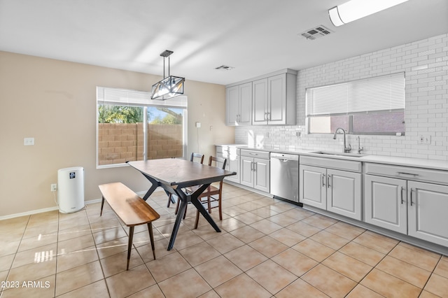 kitchen with dishwasher, light tile patterned floors, hanging light fixtures, and sink