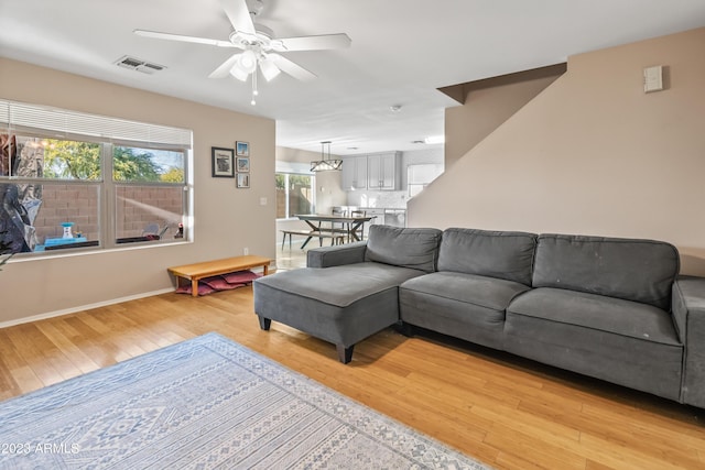 living room with ceiling fan and light wood-type flooring