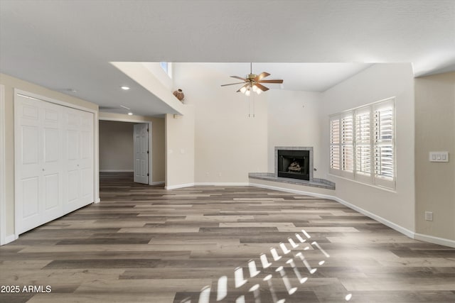 unfurnished living room with ceiling fan and dark wood-type flooring