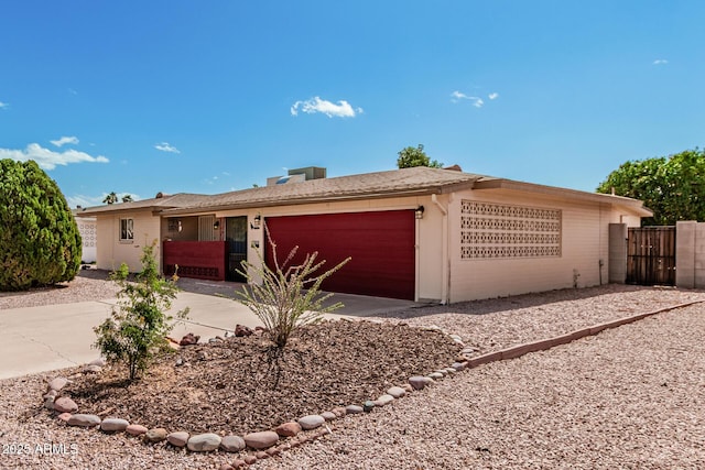 ranch-style house with a garage, fence, and concrete driveway