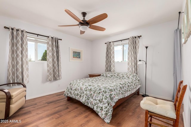 bedroom featuring dark wood finished floors, a ceiling fan, and baseboards