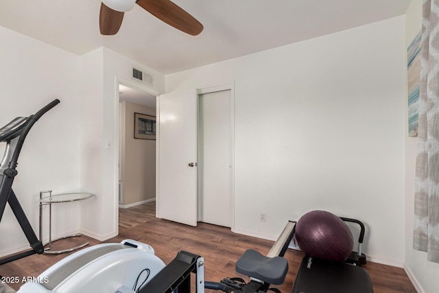 workout area with a ceiling fan, baseboards, visible vents, and wood finished floors