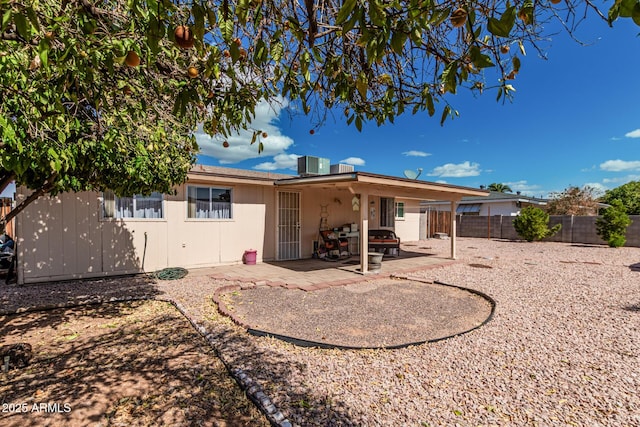 rear view of house with central AC, a patio area, and a fenced backyard