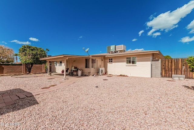 back of house with central air condition unit, a patio area, a fenced backyard, and ac unit