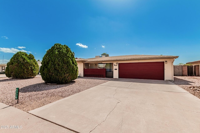 single story home with a garage, driveway, and fence