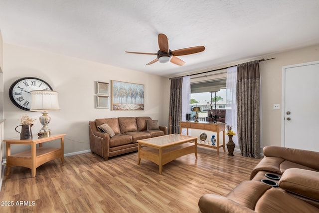 living room with light wood finished floors, ceiling fan, and baseboards