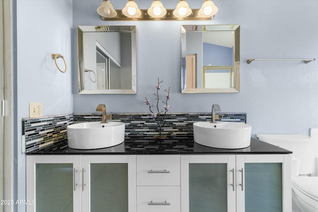 bathroom with vanity, decorative backsplash, and toilet