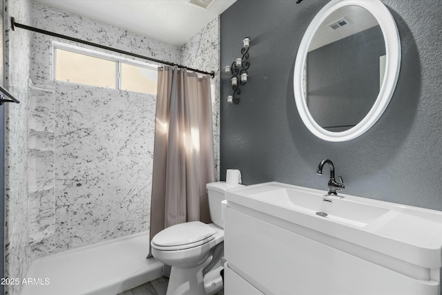 bathroom with walk in shower, vanity, and toilet