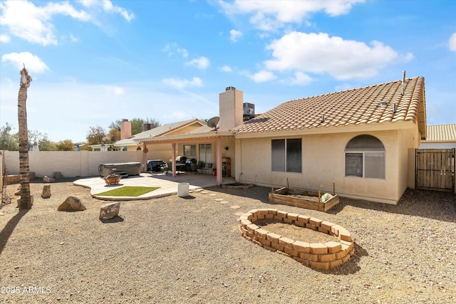 rear view of house with a patio area and a hot tub