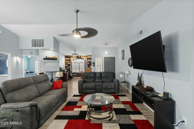 living room with lofted ceiling, ceiling fan, and light hardwood / wood-style flooring