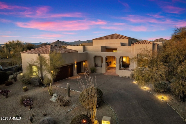 mediterranean / spanish house featuring a garage and a mountain view