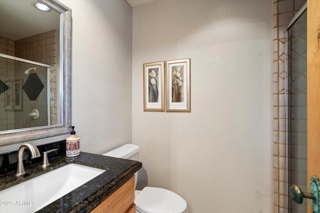 bathroom with vanity, toilet, and an enclosed shower