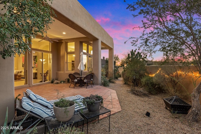 patio terrace at dusk featuring ceiling fan