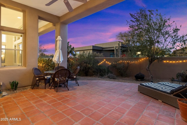 patio terrace at dusk featuring ceiling fan