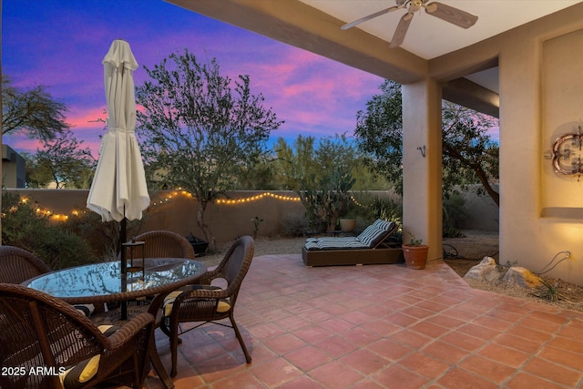 patio terrace at dusk featuring ceiling fan