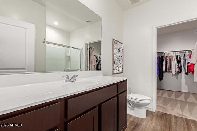 5875 N 195th Dr, Litchfield Park, AZ 85340 - bathroom with toilet, wood finished floors, vanity, a spacious closet, and a shower stall