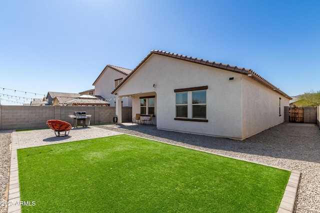 5875 N 195th Dr, Litchfield Park, AZ 85340 - rear view of house with a lawn, a fenced backyard, a tile roof, a patio area, and stucco siding
