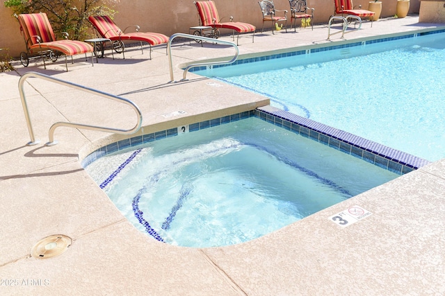 community pool with a community hot tub and a patio area