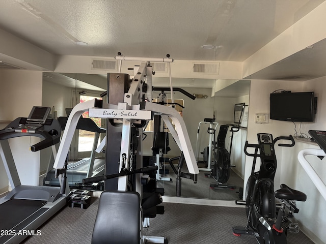 gym featuring a textured ceiling, carpet, and visible vents