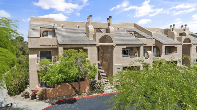 view of front of property with stairs and stucco siding