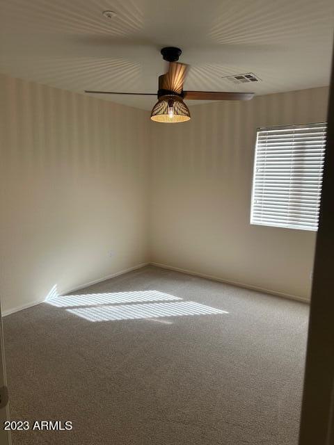 unfurnished room with ceiling fan and carpet