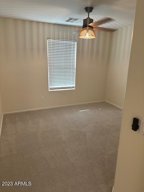 carpeted spare room featuring ceiling fan