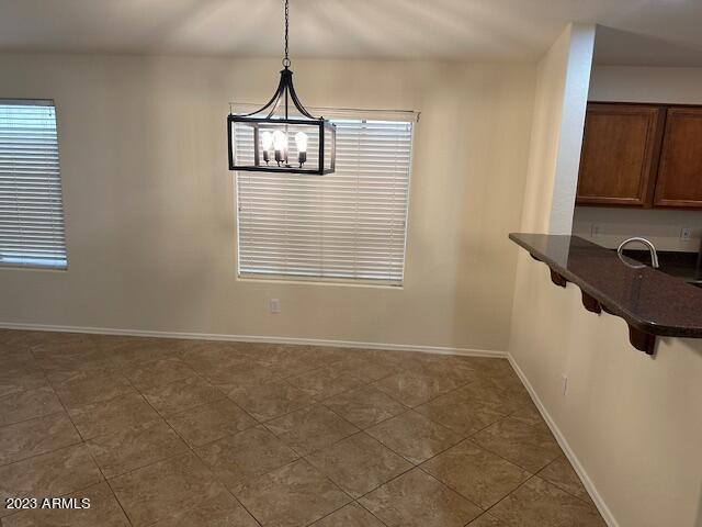 unfurnished dining area featuring a healthy amount of sunlight and dark tile patterned floors