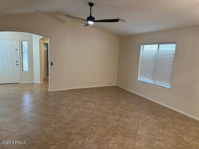 tiled empty room with lofted ceiling and ceiling fan