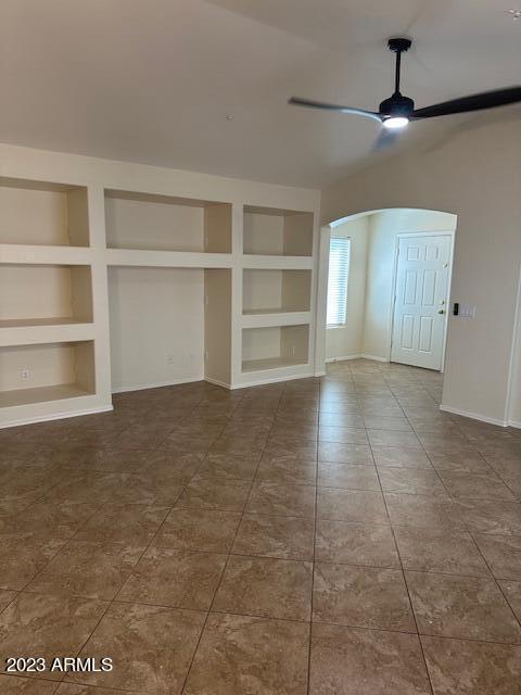 interior space featuring built in shelves and ceiling fan