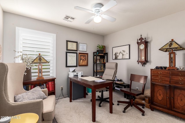 office with visible vents, a ceiling fan, and light colored carpet