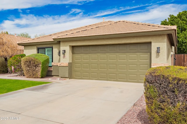 view of front facade with a garage, driveway, a tiled roof, and stucco siding