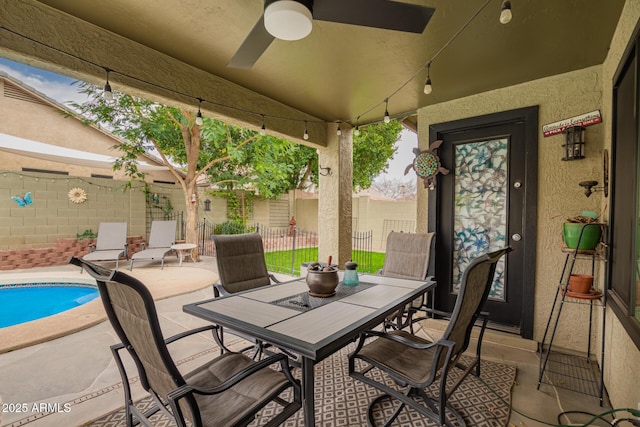 view of patio / terrace with outdoor dining space, fence, a fenced in pool, and a ceiling fan