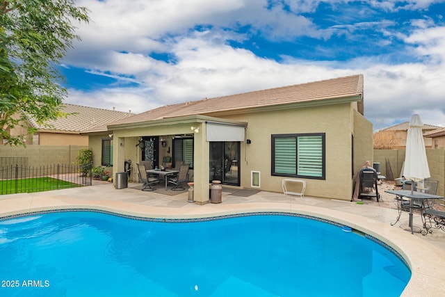 back of property with a patio area, fence, a fenced in pool, and stucco siding