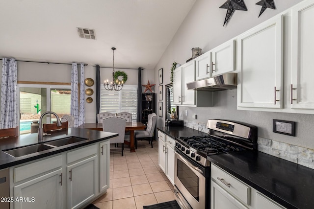 kitchen featuring under cabinet range hood, a sink, visible vents, dark countertops, and gas range