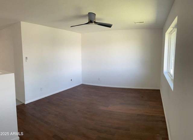 unfurnished room with dark wood-type flooring, baseboards, ceiling fan, and visible vents
