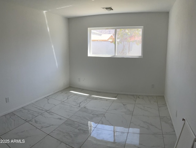empty room with visible vents, marble finish floor, and baseboards