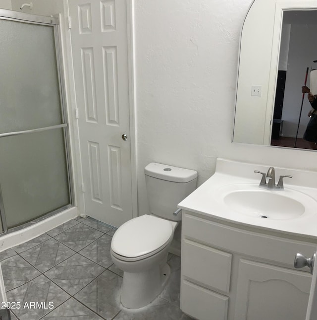 bathroom featuring vanity, toilet, and a shower stall