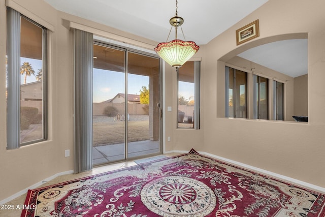 doorway featuring tile patterned floors and vaulted ceiling