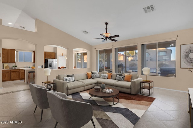 tiled living room with sink, vaulted ceiling, and ceiling fan